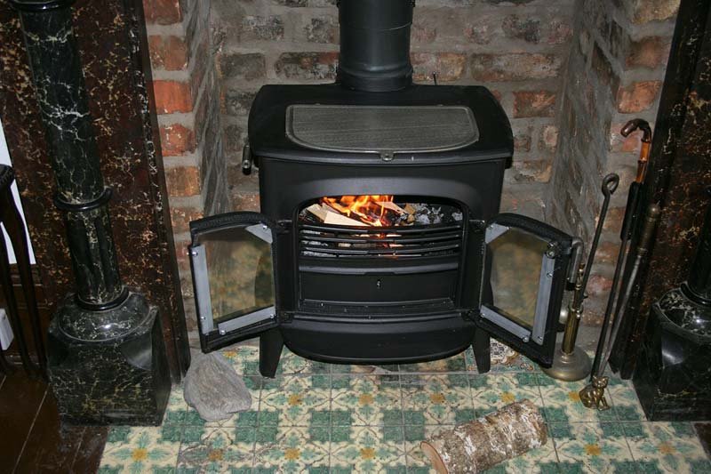 How to Operate Your Wood Stove More Efficiently, how to use a wood burning stove to heat a house, how to keep wood stove burning all night, how does a wood stove heat a house, using a wood burning stove for the first time, wood burning stove tips and tricks, how to use a wood stove damper, wood burning stove controls, how to keep a wood burner going,